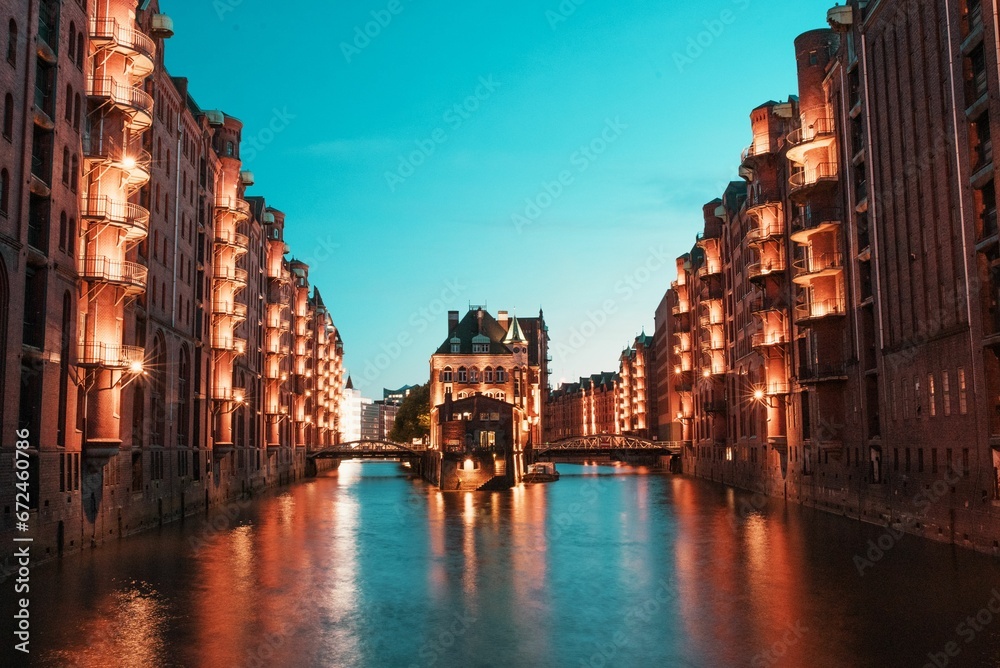 Vertical of a canal flowing through Hamburg, Germany illuminated at twilight