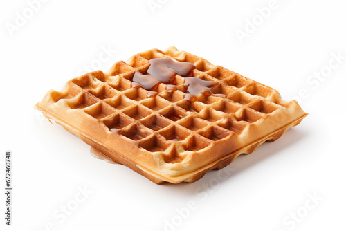 A square-shaped waffle with golden brown lattice pattern being poured with maple syrup. on white background photo