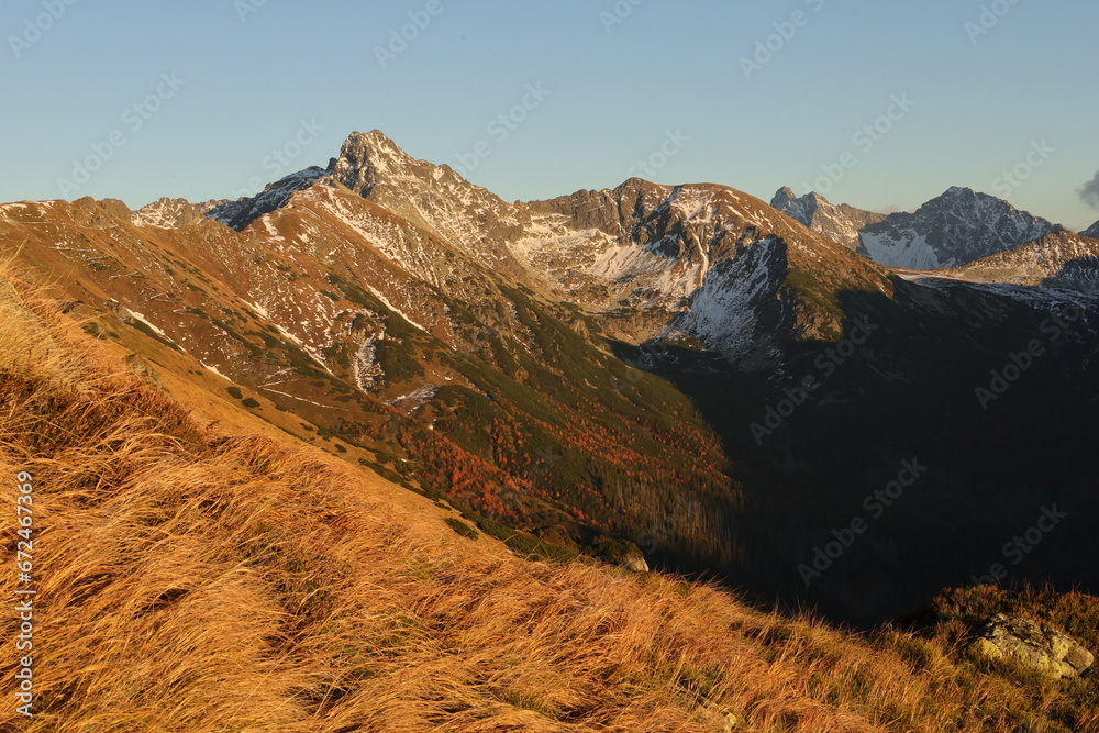 Obraz premium Górskie szczyty Tatr polskich w jesiennych barwach. Mountain peaks of the Polish Tatra Mountains in autumn colors.
