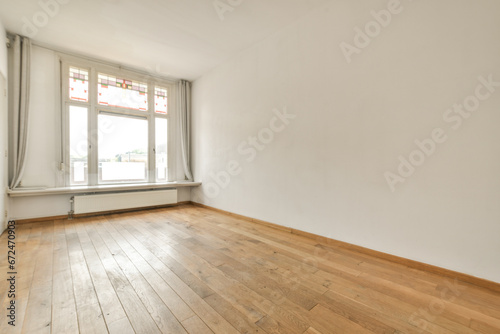 an empty room with wood flooring and white walls in the background is a large window that looks out onto the street