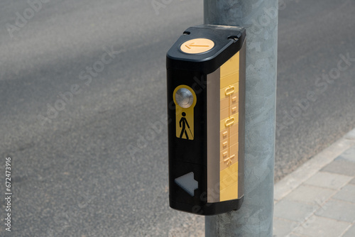 button, positioned at crosswalks.  tactile button, mounted on a pole, serves as an essential tool for blind individuals to safely cross the road photo