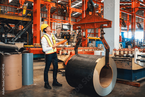 Machine operator skillfully operate steel forming machinery, making cylinder rolled steel for heavy construction engineering material in metalwork manufacturing factory. Exemplifying