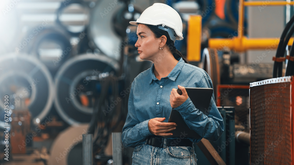 Metalwork manufacturing factory inspection, female engineer inspector with safety equipment conduct quality control on metal material in facility for heavy industry construction. Exemplifying