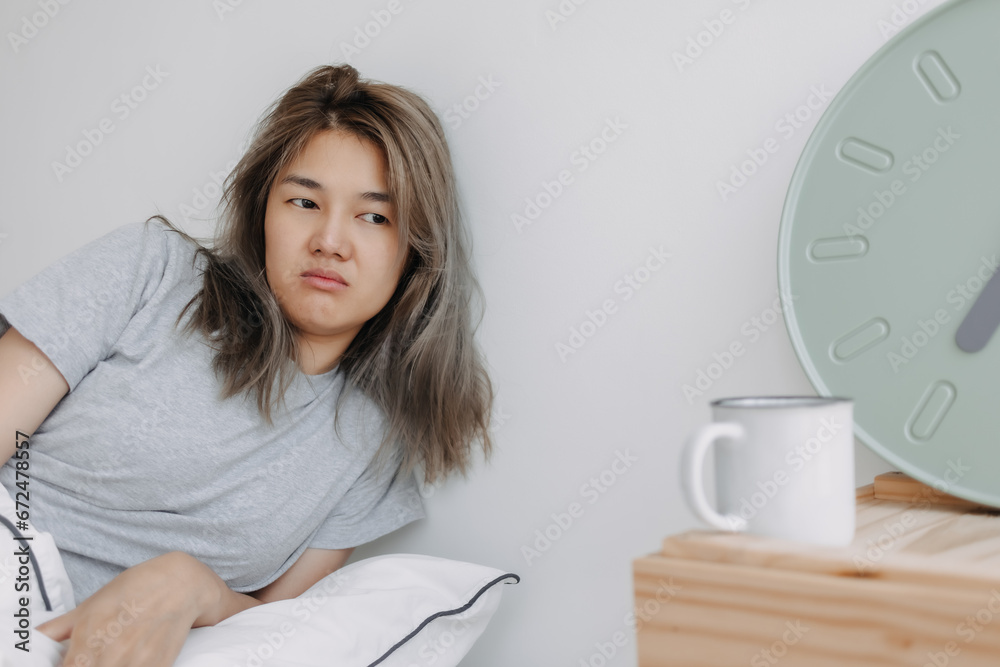 Displease and unhappy asian woman has to wake up in the morning.