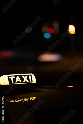 Yellow taxi car parked on a city street at night