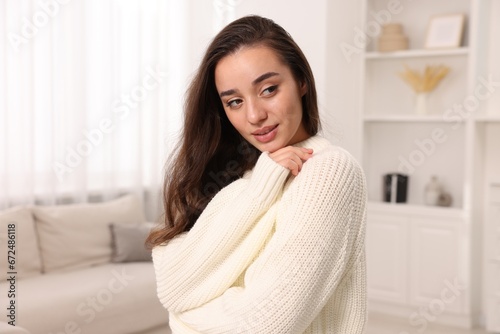 Beautiful young woman in stylish warm sweater at home