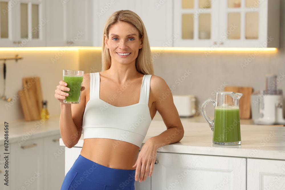 Happy woman with glass of fresh celery juice in kitchen Happy woman with glass of fresh celery juice in kitchen