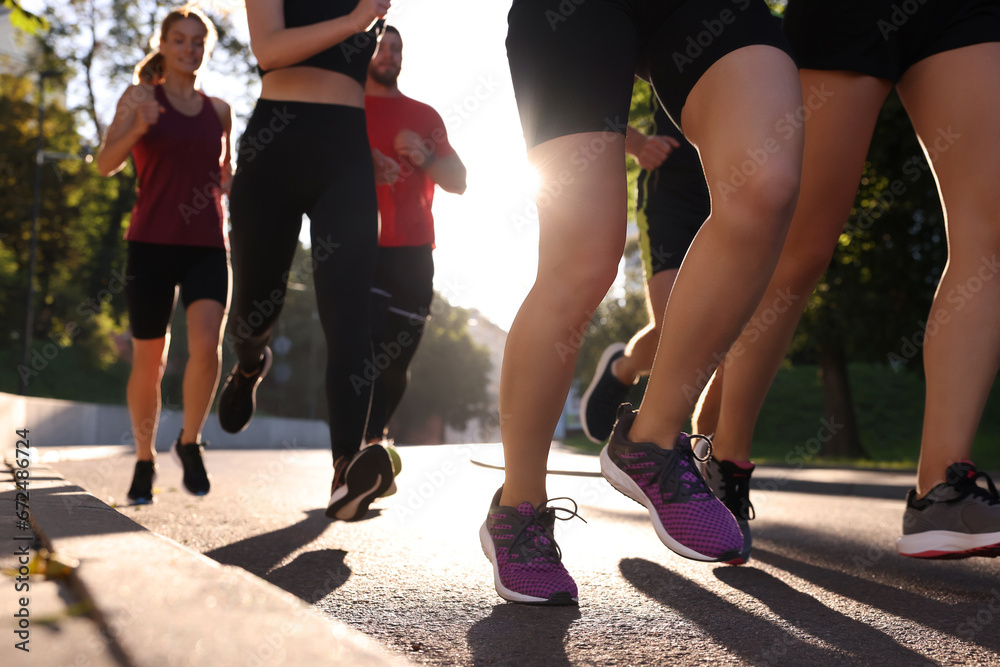 Group of people running outdoors on sunny day, closeup view Group of people running outdoors on sunny day, closeup view