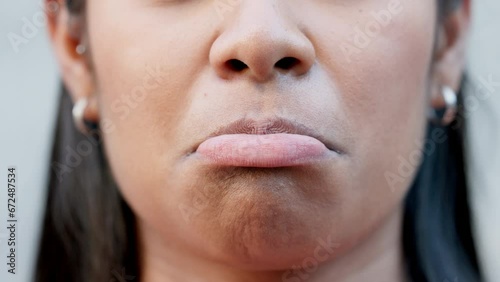 Closeup of sad mouth and pouting lips in sulking, disappointed facial expression while showing sadness. Face with detail of an unhappy woman trying not to cry while remembering past memory or mistake