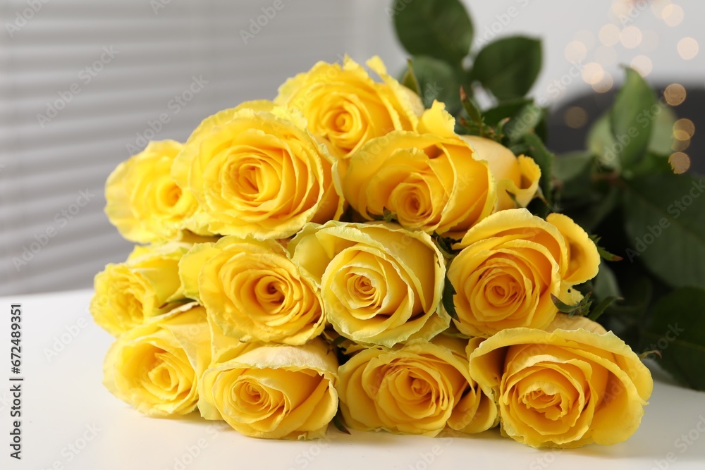 Beautiful bouquet of yellow roses on white table indoors, closeup