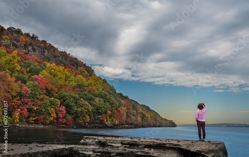 A lady in pink is enjoying the amazing Autumn view Of Hudson River in  the Palisades Interstate Park in New Jersey photo