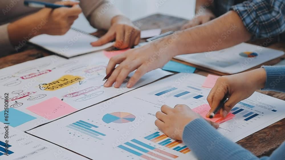 Two creative business people meeting and planning use post it notes sticky note on desk to share idea, Analysis data chart and graph with teamwork strategy brainstorming in office.