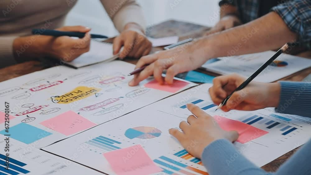 Two creative business people meeting and planning use post it notes sticky note on desk to share idea, Analysis data chart and graph with teamwork strategy brainstorming in office.