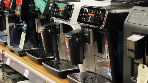 New multifunctional coffee machines for preparing different types of coffee stand in a row on the shelf of a home appliance store photo