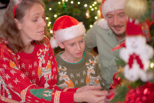 Happy Caucasian - Western family enjoy decorating a Christmas tree.