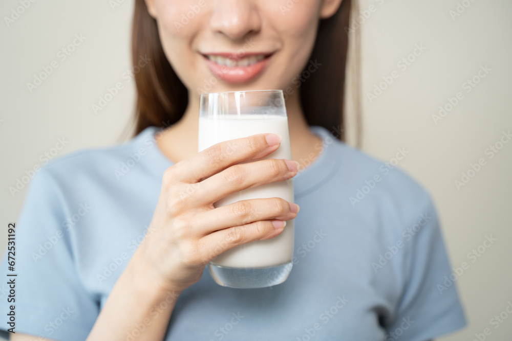Asian young woman drinking a glass of milk isolated on background. Asian young woman drinking a glass of milk isolated on background.