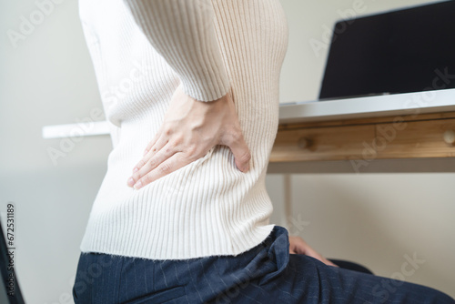 office syndrome, woman with back pain symptoms during work in the office. photo