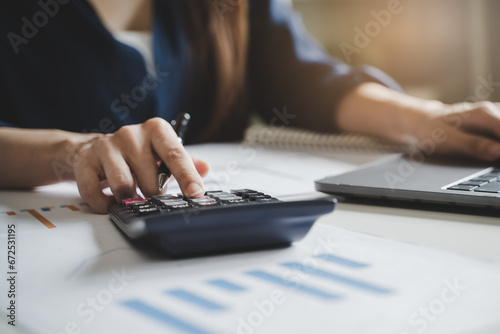 Billede på lærred Women business people use calculators to calculate the company budget and income reports on the desk in the office