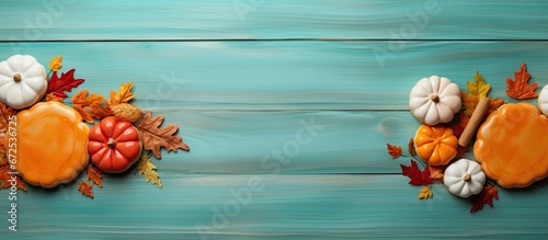 Pumpkin pie and sugar cookies decorated with candy corn arranged on a rustic turquoise painted wooden surface alongside pumpkins
