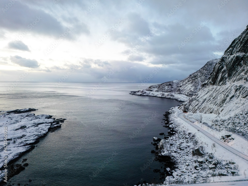 Aerial view of Lofoten island Norway. top view of sea and island with village. Norway with red rorbu houses. With falling snow in winter. Aerial view of Lofoten island Norway. top view of sea and island with village. Norway with red rorbu houses. With falling snow in winter.