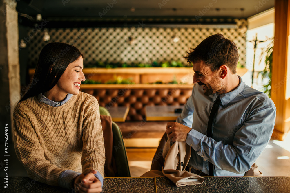 Couple handling laptop tasks and phone calls over coffee and juice in a bustling cafe Couple handling laptop tasks and phone calls over coffee and juice in a bustling cafe