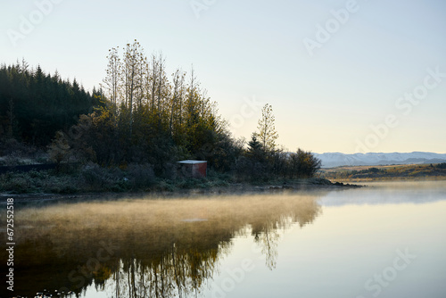 Fog over calm lake in autumn morning