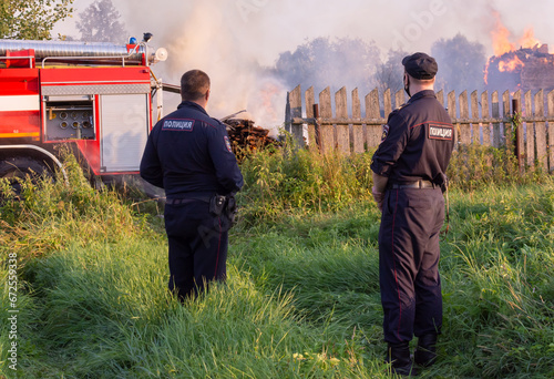 Russia, Tver region, village of Rantsevo - July 2021.Police officers arrived at the scene of the fire. A fire in the village. An emergency situation. photo