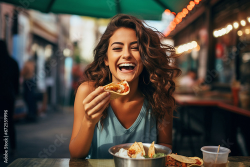 Mexican woman eating tacos	 photo
