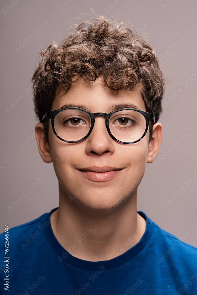 Teenage boy with glasses portrait - Young male smiling headshot: Happy adolescent with curly hair