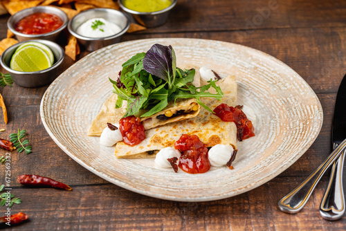 Mexican food molotes with sauces on wooden table photo