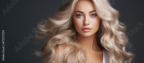 The elegant hairstyle of a beautiful girl with blonde hair includes waves and curls