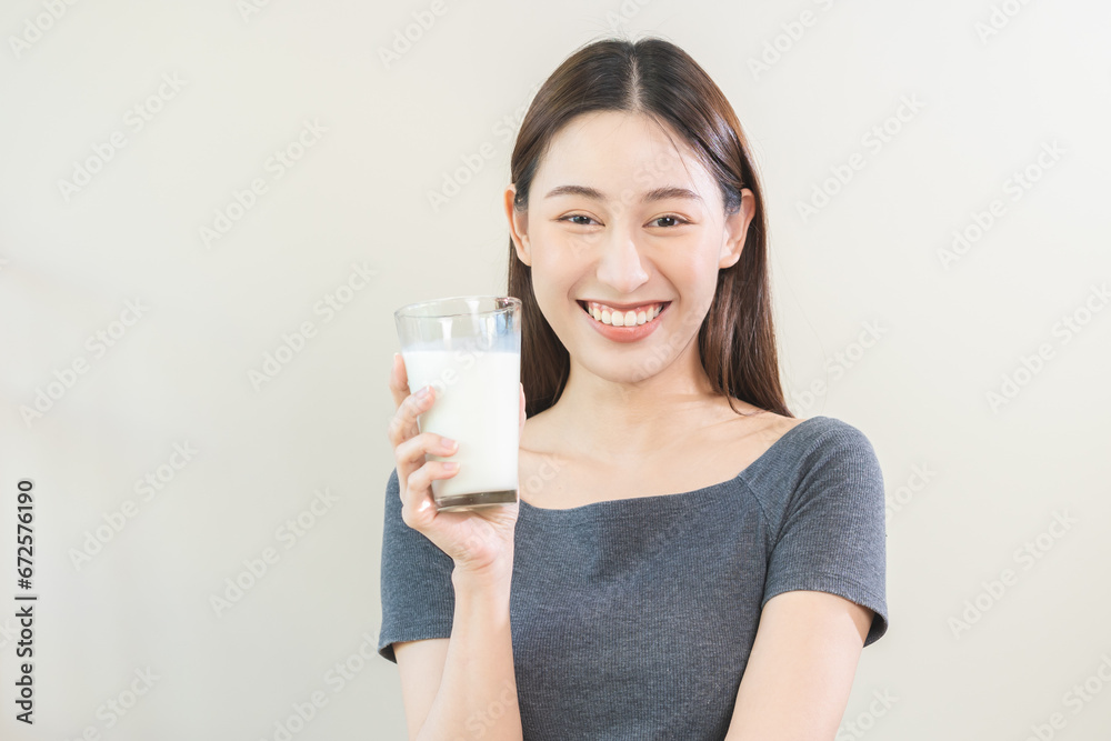 Happy, asian young woman, girl drinking a glass of white fresh, warm or hot dairy milk for calcium, vitamin wholesome good nutrition in morning. lifestyle, product healthy people, Isolated background. Happy, asian young woman, girl drinking a glass of white fresh, warm or hot dairy milk for calcium, vitamin wholesome good nutrition in morning. lifestyle, product healthy people, Isolated background.