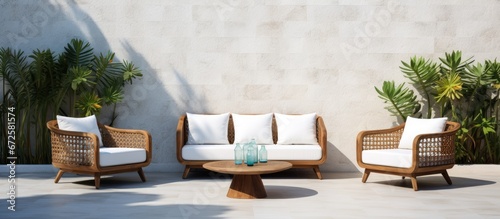 The seating area by the pool in Bali features white block walls and rattan furniture surrounded by cacti photo