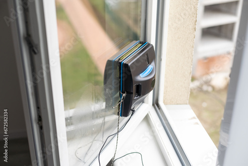 Robot window cleaner work on dirty window. Cleaning the house with smart devices. Automatic vacuum robots for cleaning windows, an assistant for the home.