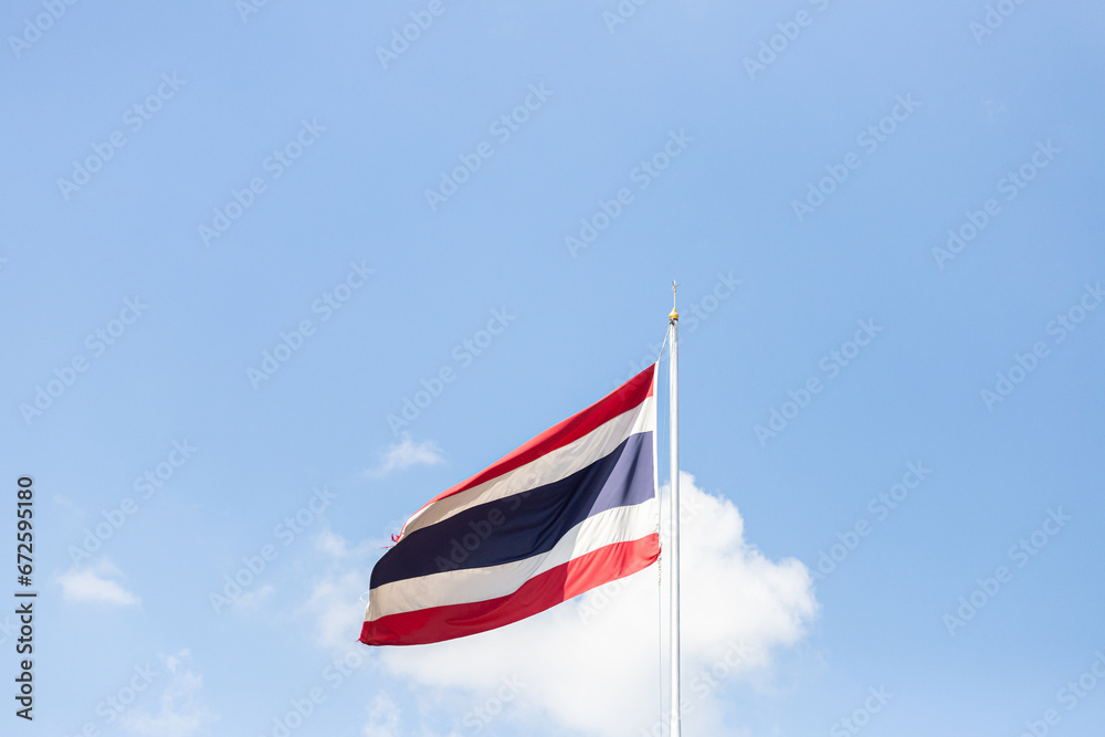 Thailand flag waving in the wind on blue sky with white cloud