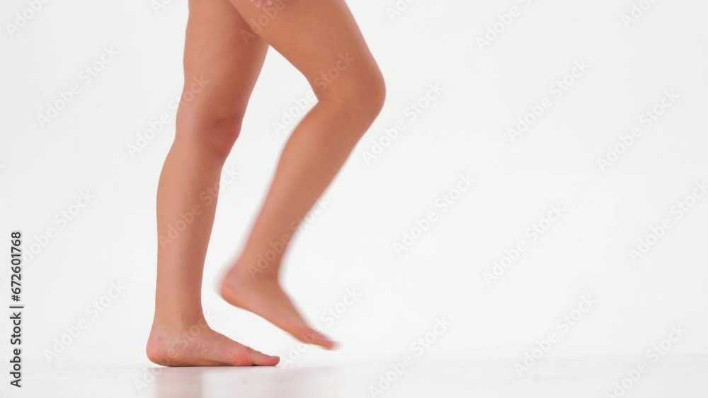 female bare legs walking on a white background . slow motion female bare legs walking on a white background . slow motion