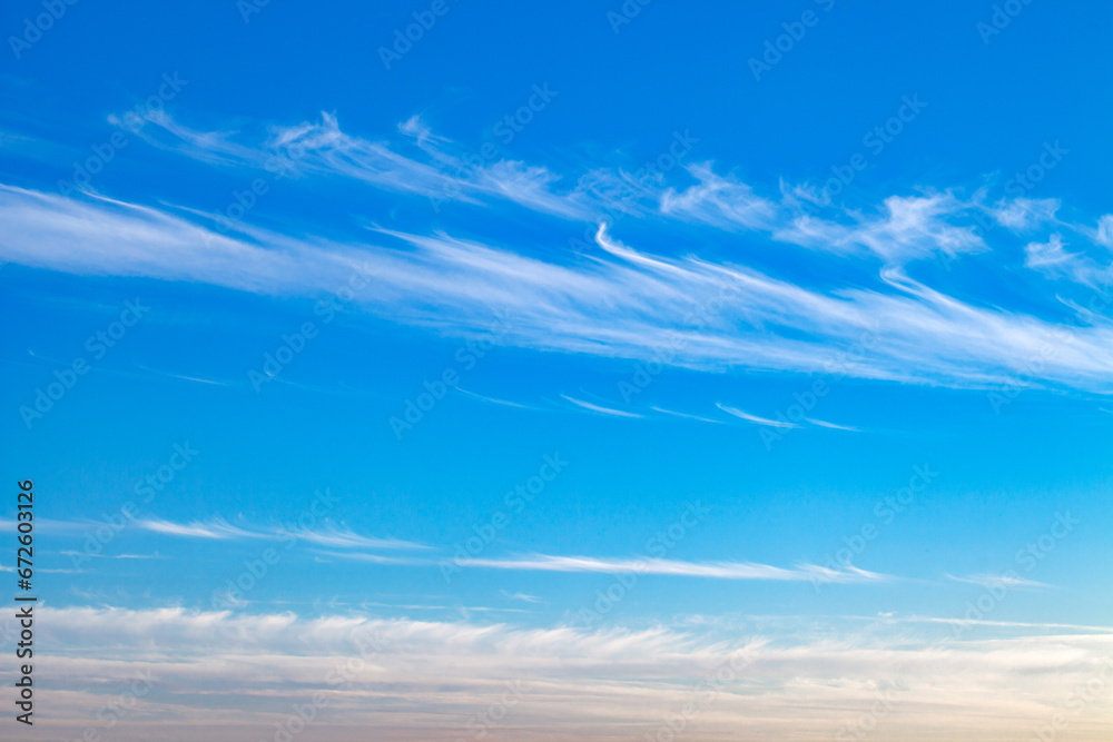 Feathery white sparse clouds in blue sky at day