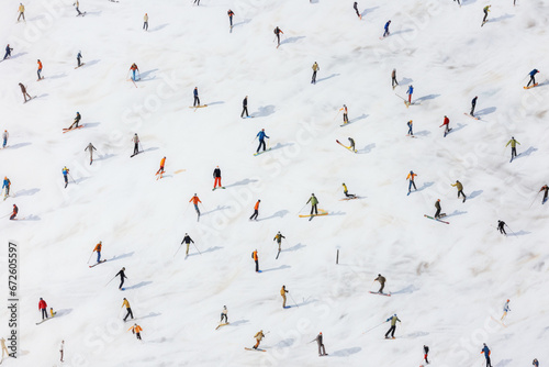 Aerial view of unrecognizable skiers on mountain ski slope skiing downhill and enjoying winter sport activity