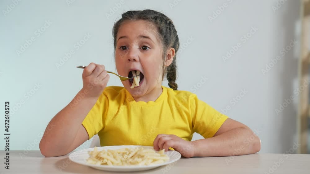 Happy family concept. baby in kindergarten. the child sits eating pasta for lunch. food in kindergarten. happy baby eats delicious pasta. healthy eating in kindergarten. portrait of baby eating pasta Happy family concept. baby in kindergarten. the child sits eating pasta for lunch. food in kindergarten. happy baby eats delicious pasta. healthy eating in kindergarten. portrait of baby eating pasta