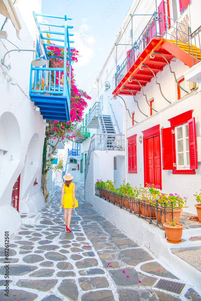 Woman in yellow dress at the Streets of old town Mykonos during a vacation in Greece, Little Venice Mykonos Greece