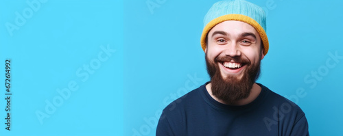 A pleased smiling young american man look at camera, Cheerful optimistic bearded guy, aside charming smile isolated on blue color background studio portrait happy People lifestyle concept