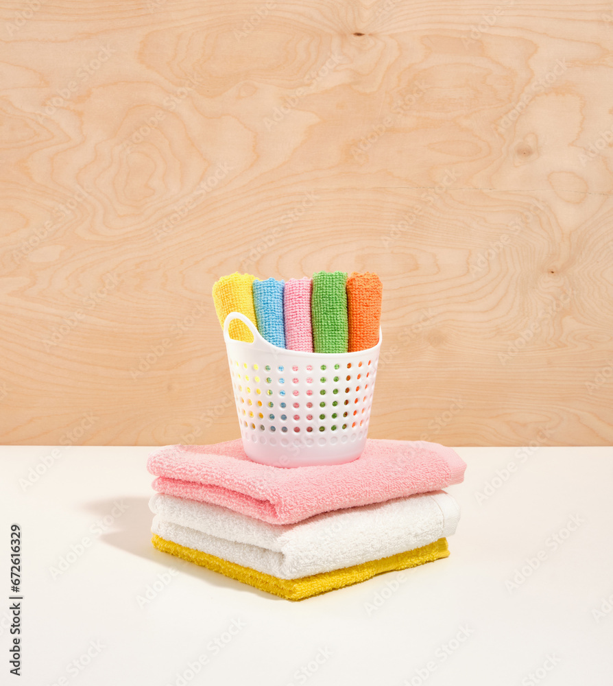 Laundry basket with small clean, soft towels stand on a large, fresh shower colorful towels. Laundry basket with small clean, soft towels stand on a large, fresh shower colorful towels.