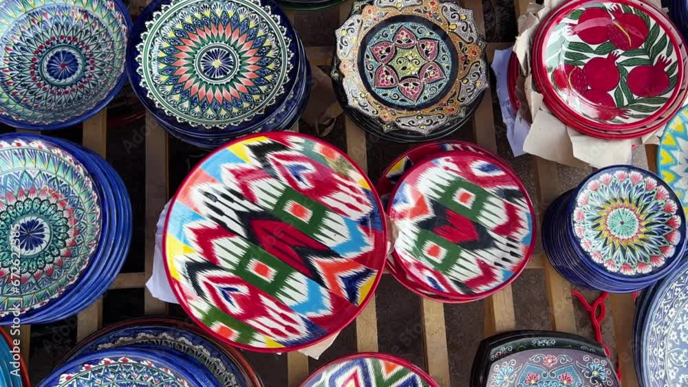 Uzbek national ceramic tableware in Tashkent - June 29, 2023: Goods at the Oriental Bazaar in Uzbekistan. Chorsu Market. Plates, teapots, cups. Painting with floral ornament. 4K Uzbek national ceramic tableware in Tashkent - June 29, 2023: Goods at the Oriental Bazaar in Uzbekistan. Chorsu Market. Plates, teapots, cups. Painting with floral ornament. 4K