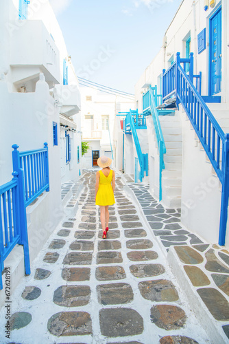 Woman in yellow dress at the Streets of old town Mykonos during a vacation in Greece, Little Venice Mykonos Greece © Kyrenian