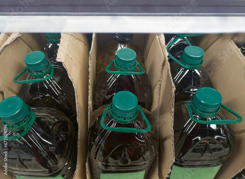 Extra virgin olive oil bottled and displayed on cardboard box at supermarket shelve photo