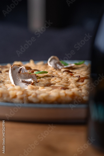 Dish of risotto with porcini mushrooms on grey plane