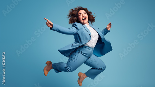 Full length portrait of a happy businesswoman jumping on blue background photo