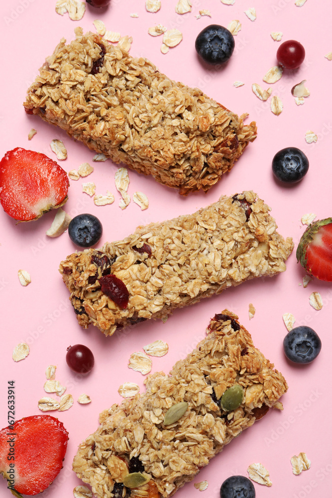 Fototapeta premium Tasty granola bars and ingredients on pink background, flat lay