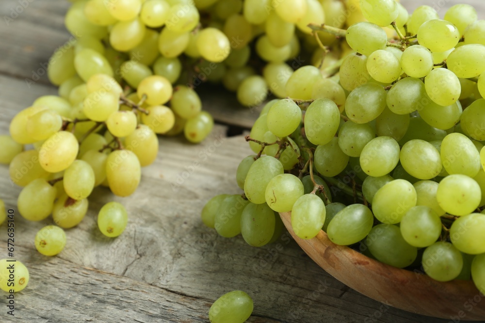 Delicious fresh green grapes on wooden table, closeup Delicious fresh green grapes on wooden table, closeup