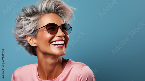 Beautiful mid age woman with grey hair. Laughing and smiling. Blue background. Nature lady close up portrait. Healthy face skin care beauty, skincare cosmetics. High quality